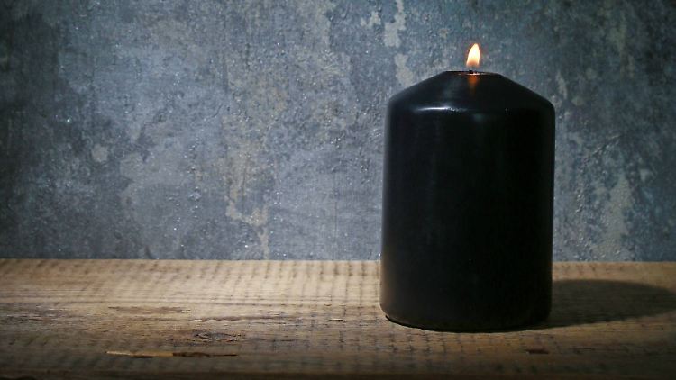 Was hat die entzündete, schwarze Stumpenkerze in einem unbewohnt wirkenden Haus zu bedeuten?