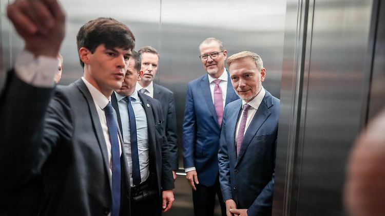 Finanzminister Lindner und Wirtschaftsvertreter im Aufzug: Geht es jetzt aufwärts oder weiter abwärts?