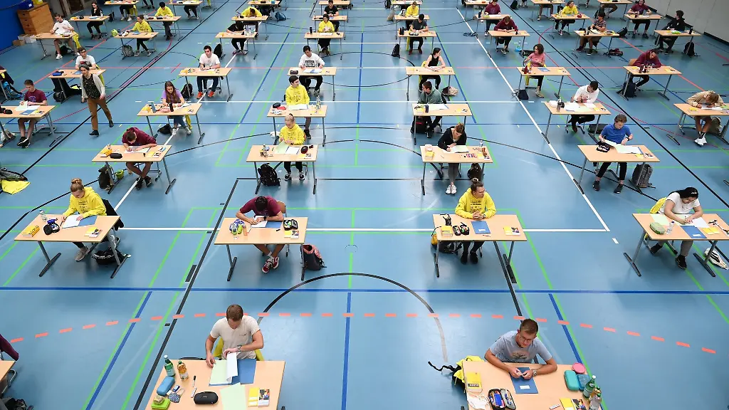 Schueler-und-Schuelerinnen-sitzen-waehrend-der-Deutsch-Abiturspruefung-in-der-Sporthalle-des-Albert-Einstein-Gymnasiums-vor-ihren-Pruefungsaufgaben