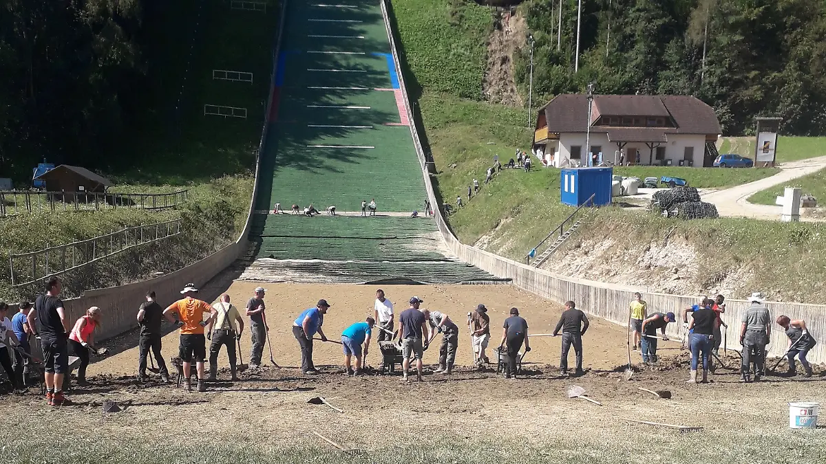Helfer-beseitigen-Schaeden-an-der-Skisprunganlage-in-Ljubno
