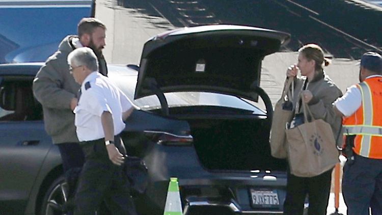Ben Affleck und seine noch nicht identifizierte Begleitung scheinen sich auf ihren Flug zu freuen.