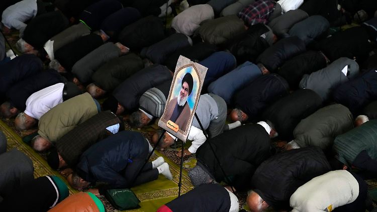 Ein Poster des getöteten Hisbollah-Führers Nasrallah inmitten von Betenden in Teheran im Iran.