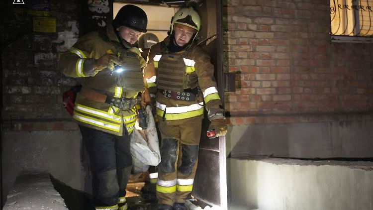 Feuerwehrleute tragen die Leiche einer Person, die bei dem russischen Drohnenangriff auf Mykolajiw getötet wurde, aus einem Gebäude.