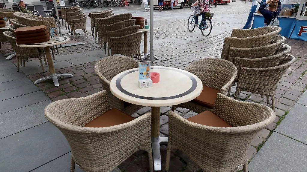 Auf-dem-Marktplatz-werden-Tische-und-Stuehle-fuer-Besucher-eines-Restaurants-aufgestellt