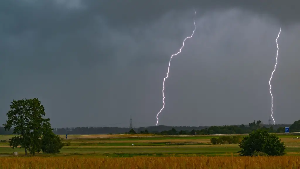 Zwei-Blitze-leuchten-am-Himmel-ueber-einer-Landschaft-im-Osten-von-Brandenburg