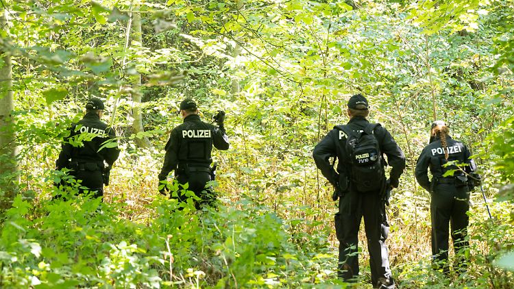 Polizisten durchsuchen ein Waldstück nach Spuren. In der Nähe wurde im Sommer 2022 die Leiche der jungen Frau im Auto der Angeklagten entdeckt.