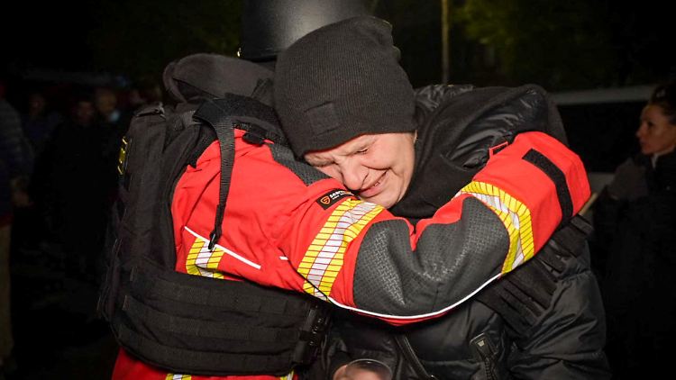 Ein Psychologe des Rettungsdienstes umarmt eine Frau, die aus einem Wohnhaus in Odessa evakuiert wurde.