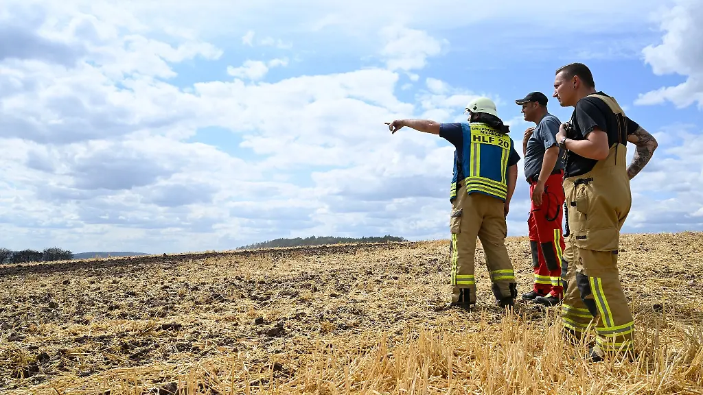 Einsatzkraefte-der-Feuerwehr-begutachten-die-Brandstelle