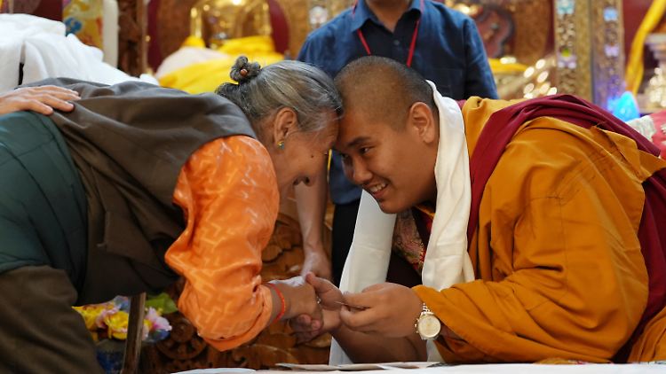 Jalue Dorje begrüßt ein Mitglied der Gemeinde mit dem traditionellen tibetischen Gruß.