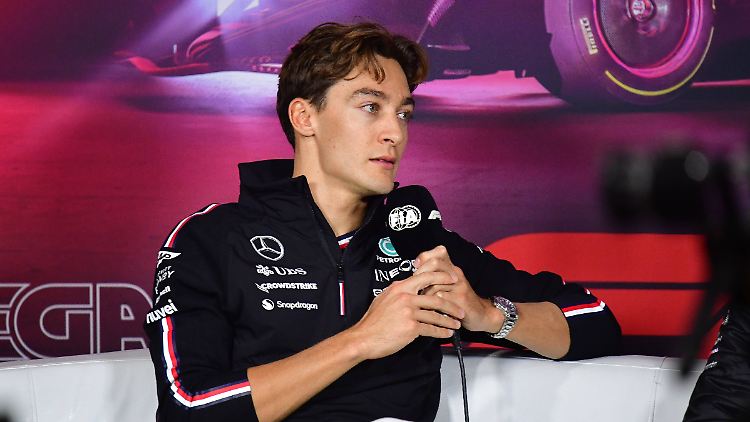 George Russell hält in Las Vegas ein Mikrofon der FIA in der Hand.