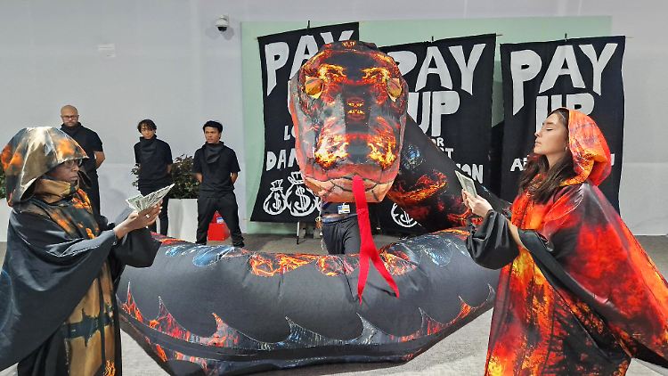 Aktivisten stellen bei einem Protest auf dem UN-Klimagipfel COP29 eine Schlange dar, die für die Vielzahl an Lobbyisten für Kohle, Öl und Gas steht, die an der Konferenz teilnehmen.