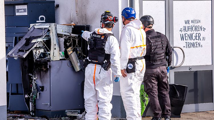 Polizisten untersuchen einen gesprengten Geldautomaten vor einem Getränkemarkt in Mecklenburg-Vorpommern. 