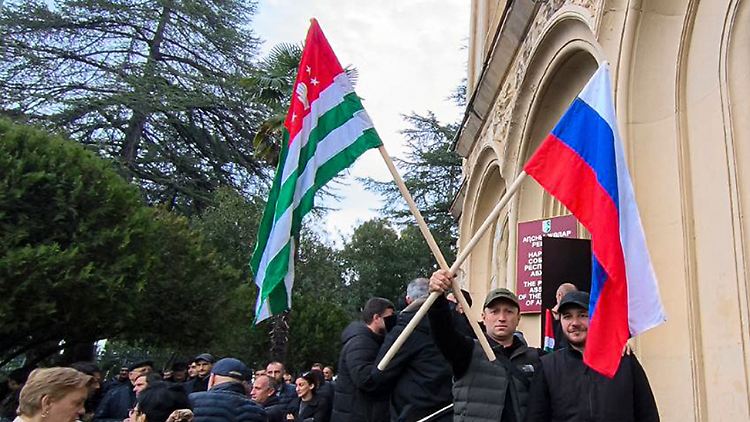 Demonstranten mit den Flaggen von Abchasien und Russland vor dem Parlament in Sochumi.