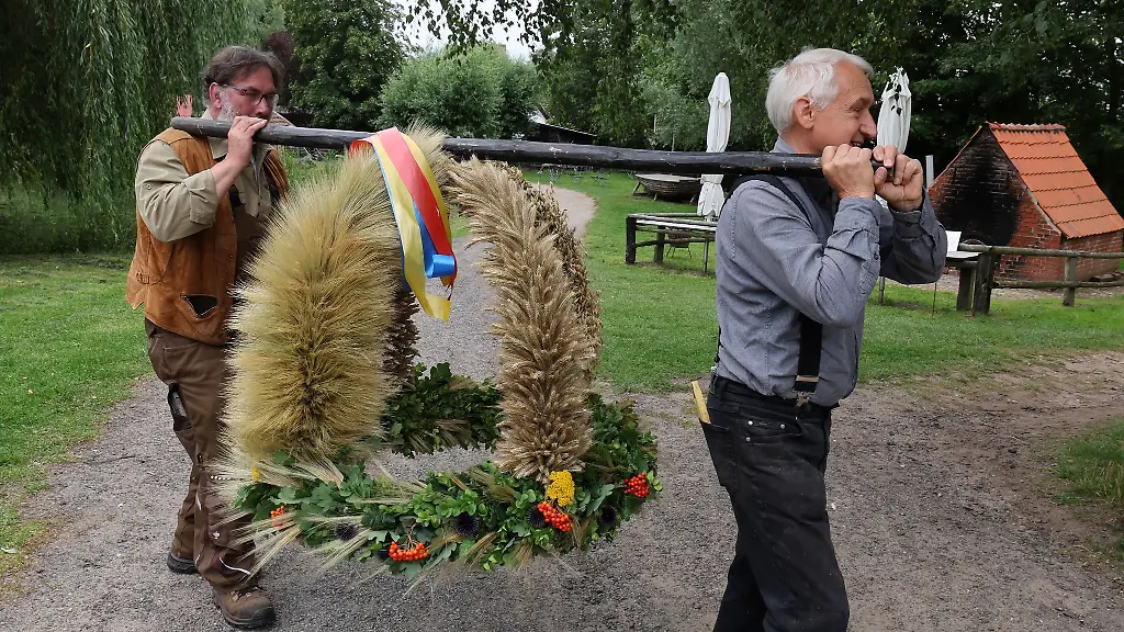 Martin-Krybus-l-und-Lutz-Donath-bringen-die-letzte-Erntekrone-zur-Ausstellung-im-Freilichtmuseum-Klockenhagen