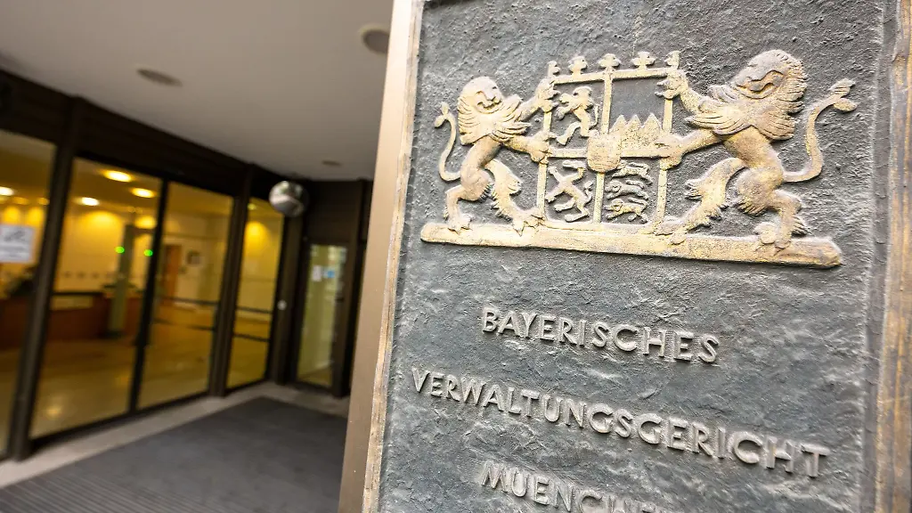 Ein-Schild-mit-dem-bayerischen-Wappen-und-der-Aufschrift-Bayerisches-Verwaltungsgericht-Muenchen