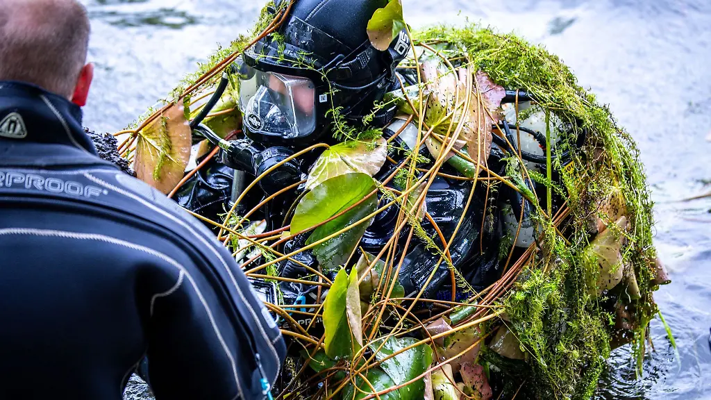 Unter-Seegras-und-Wasserpflanzen-holt-ein-Taucher-der-Landespolizei-bei-einem-Uebungseinsatz-ins-Wasser-geworfene-Stuehle-und-Tische-aus-einem-Ausflugslokal-aus-dem-Lankower-See