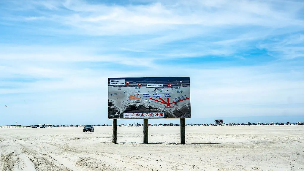 Ein-Hinweisschild-fuer-Autofahrer-zeigt-am-Strand-von-St-Peter-Ording-die-Anfahrtswege-zur-Kite-Surf-zur-Bade-und-zur-FKK-Zone-an