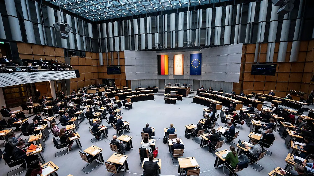 Abgeordnete-stehen-im-Plenarsaal-des-Berliner-Abgeordnetenhauses