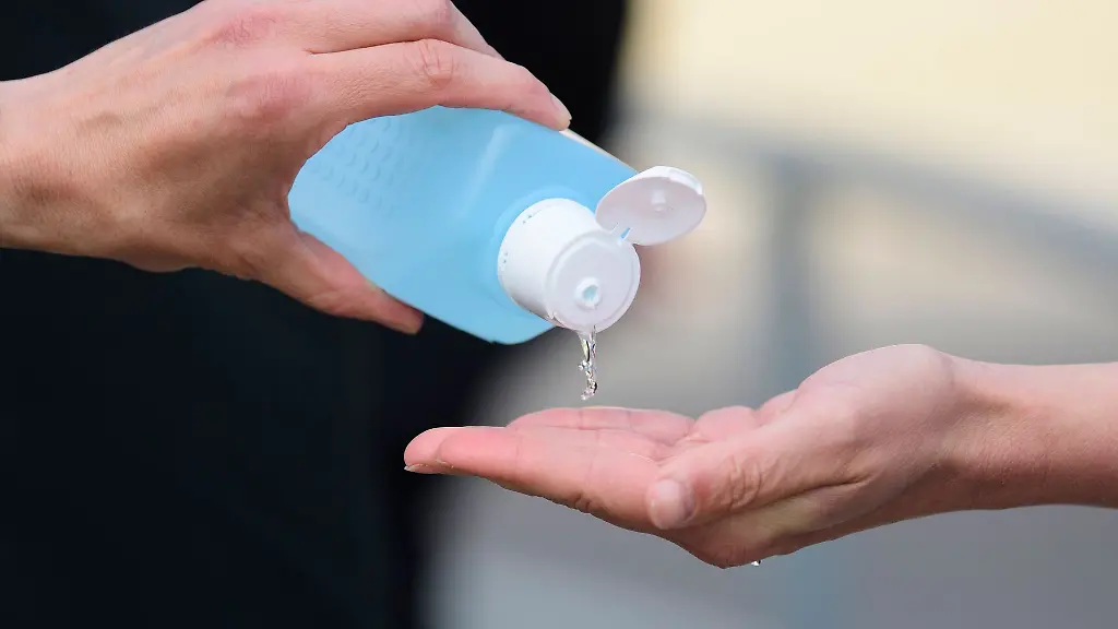 Desinfektionsmittel-wird-aus-einer-Flasche-auf-eine-Hand-gegossen