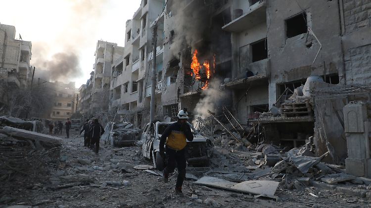 Ein syrischer Weißhelm-Zivilschutzmitarbeiter läuft durch ein zerstörtes Viertel der Stadt Idlib.