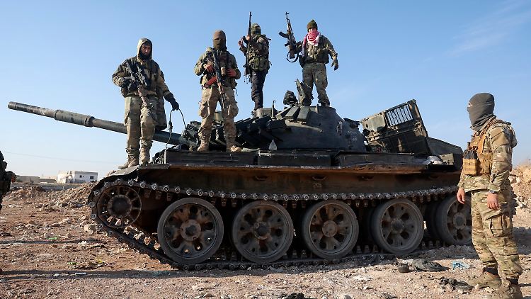 Syrische Oppositionskämpfer stehen in den vergangenen Tagen auf einem beschlagnahmten gepanzerten Fahrzeug der syrischen Armee in den Außenbezirken von Hama.
