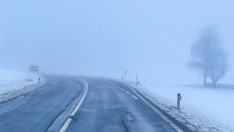 Eine winterliche Straße im Nebel. 