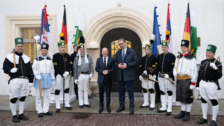 Scholz und Vucic vor dem sächsischen Oberbergamt - umgeben von Männern in traditioneller Bergmannskluft.