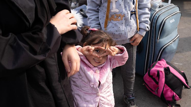 Ein Mädchen, das nach dem Assad-Sturz mit ihrer Familie aus der Türkei zurück nach Syrien reist, lächelt in die Kamera. 