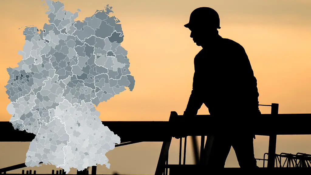 Niedersachsen-Hannover-Die-Silhouette-eines-Bauarbeiters-zeichnet-sich-auf-einer-Baustelle-vor-dem-verfaerbten-Morgenhimmel-ab