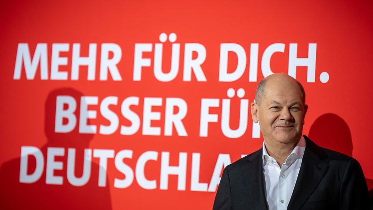 Scholz zeigt sich vor dem neuen Wahlkampfslogan seiner Partei.