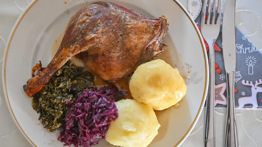 Eine-Entenkeule-mit-Kloessen-Rotkohl-und-Gruenkohl-wird-serviert