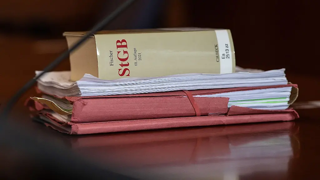 Das-Strafgesetzbuch-und-Akten-liegen-in-einem-Gericht-auf-dem-Tisch