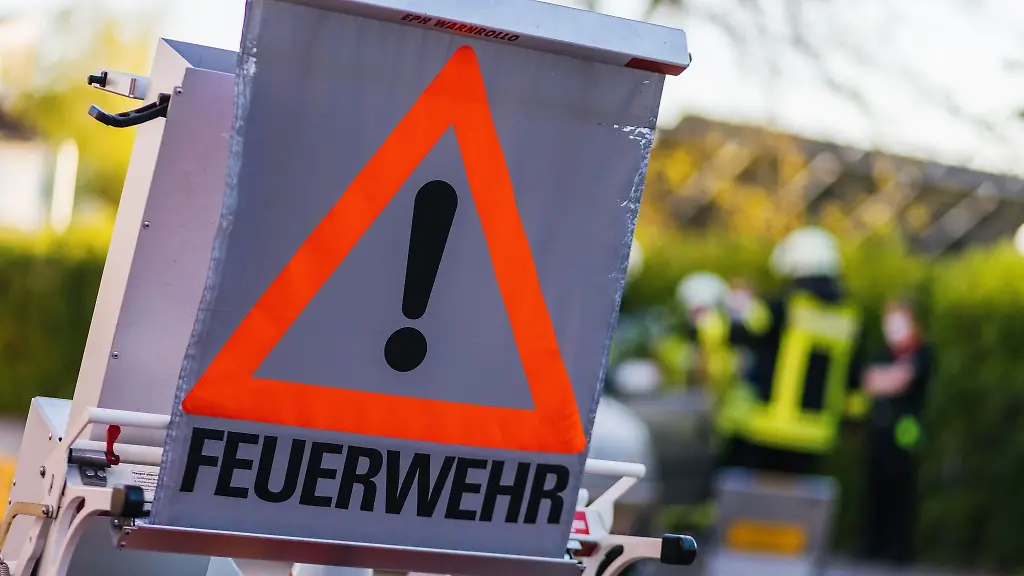 Ein-Schild-mit-der-Aufschrift-Feuerwehr-steht-auf-dem-Hof-eines-Feuerwehrgeraetehauses