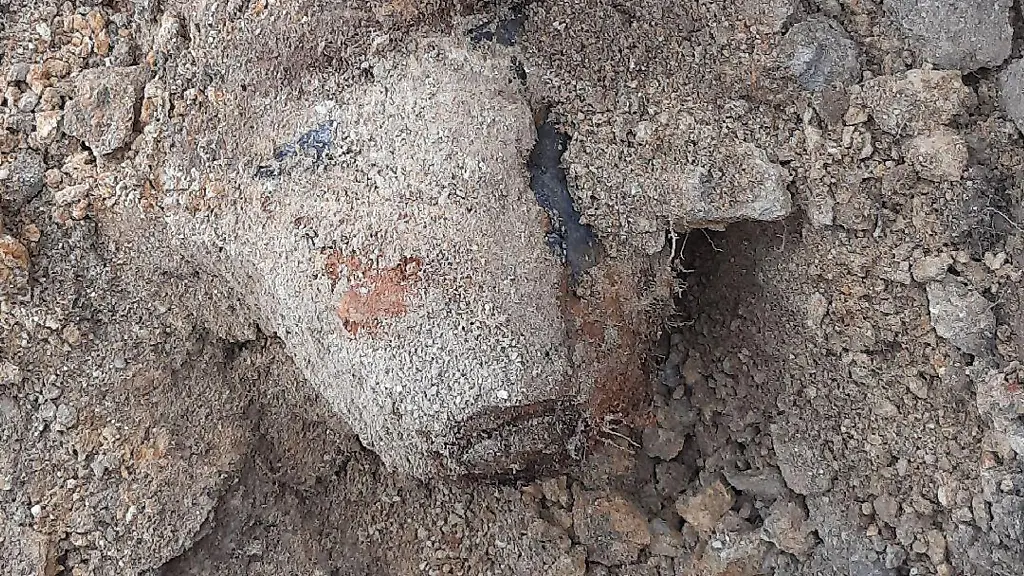 Ein-Teil-einer-Fliegerbombe-ist-im-Erdreich-zu-erkennen