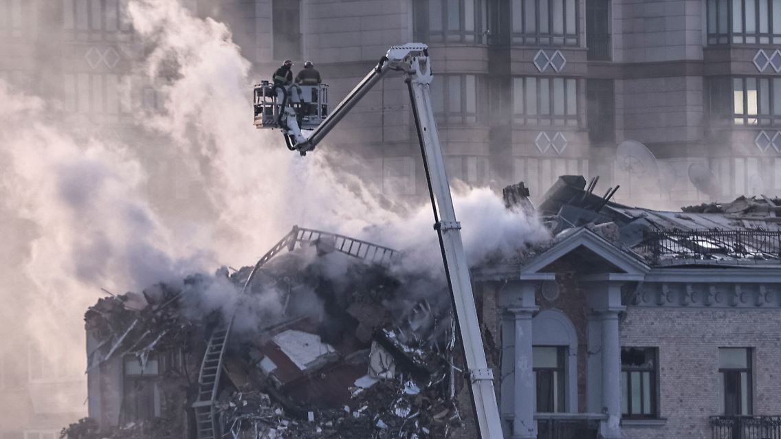 Nach einem russischen Drohnenangriff löschen Feuerwehrleute ein teilweise eingestürztes Gebäude in Kiew.