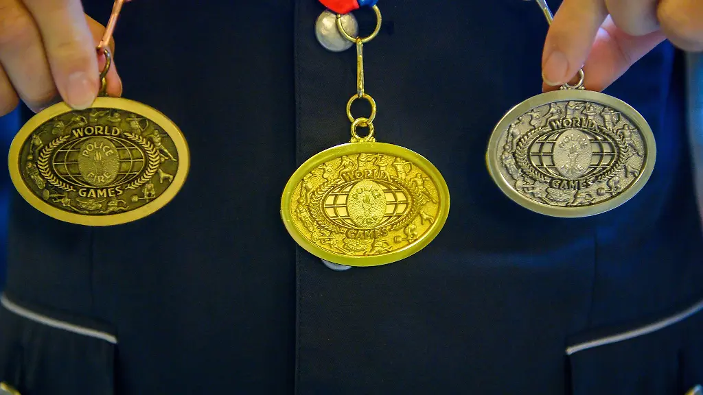 Ein-Polizist-zeigt-beim-Empfang-fuer-die-Teilnehmer-der-World-Police-and-Fire-Games-seinen-gewonnenen-Medaillensatz