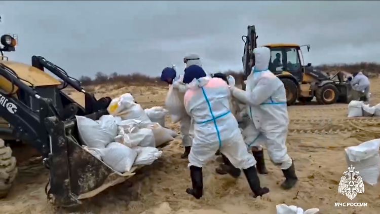 Retter und Freiwillige versuchen Tonnen von ausgelaufenem Heizöl am Strand im südlichen Russland zu beseitigen.