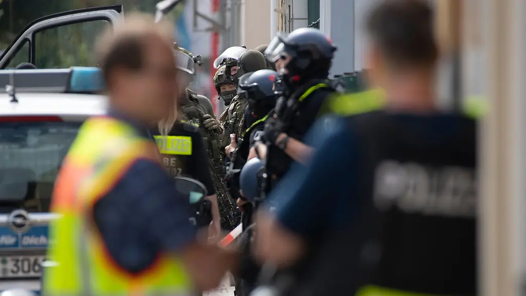 Bewaffnete-Polizeikraefte-stehen-unweit-eines-Hauses-am-Brunsbuetteler-Damm