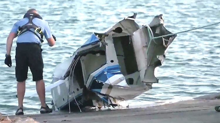 Ermittler untersuchen, was vom Wasserflugzeug übrig ist.