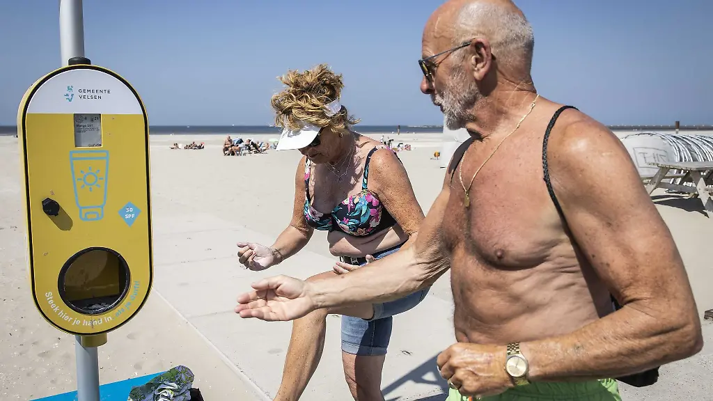 Ein-Spender-mit-kostenlosem-Sonnenschutz-steht-an-einem-Strand-um-Besucher-vor-Sonnenbrand-zu-schuetzen