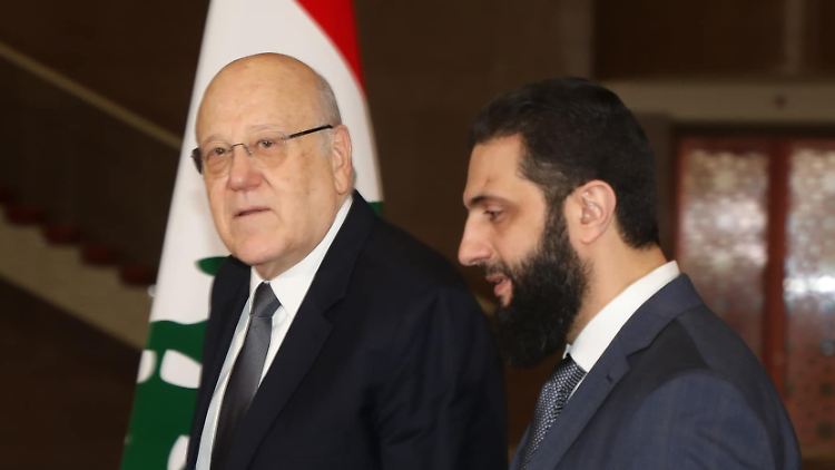 Mikati (l.) und al-Scharaa (r.) in Damaskus - im Hintergrund eine Flagge des Libanon.