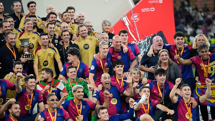 Hansi Flick (mit Pokal) inmitten seines "unglaublichen Teams".