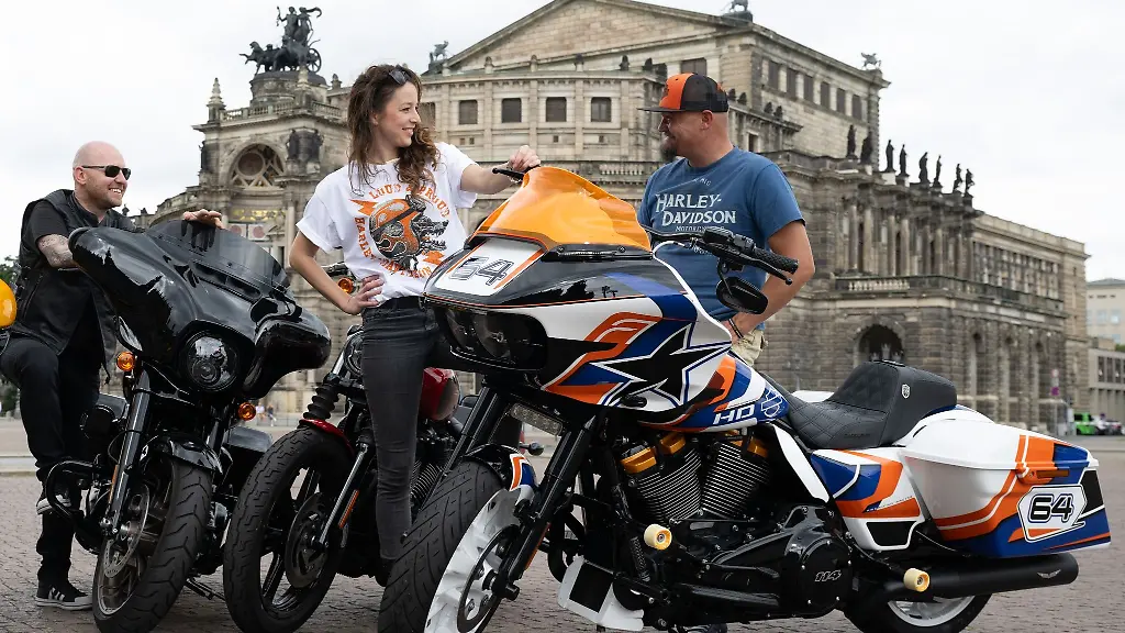 Teilnehmer-eines-Pressetermins-stehen-auf-dem-Theaterplatz-vor-der-Semperoper-an-verschiedenen-Harley-Davidson-Motorraedern