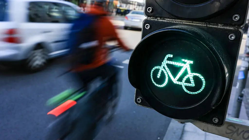 Eine-Radfahrerin-faehrt-bei-Gruen-ueber-eine-Fahrradampel