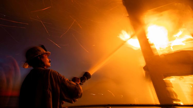 Ein Feuerwehrmann bekämpft Flammen des Palisade-Feuers.