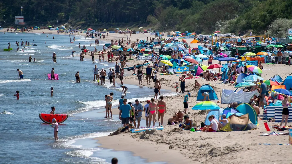 Zahlreiche-Menschen-sind-bei-sonnigem-Wetter-am-Strand-der-Insel-Usedom-unterwegs