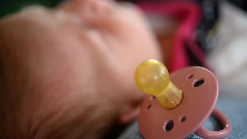 Ein-Schnuller-liegt-neben-einem-Neugeborenen