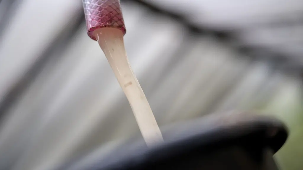 Grundwasser-laeuft-aus-einem-Schlauch-der-per-Pumpe-an-einen-Grundwasserbrunnnen-angeschlossen-ist-in-einen-Eimer