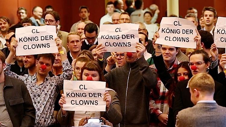 Protestierende halten Plakate im Kolpinghaus hoch.