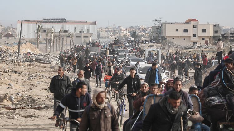 Vertriebene Palästinenser passieren Trümmer, als sie versuchen, in ihre Häuser in Rafah zurückzukehren.
